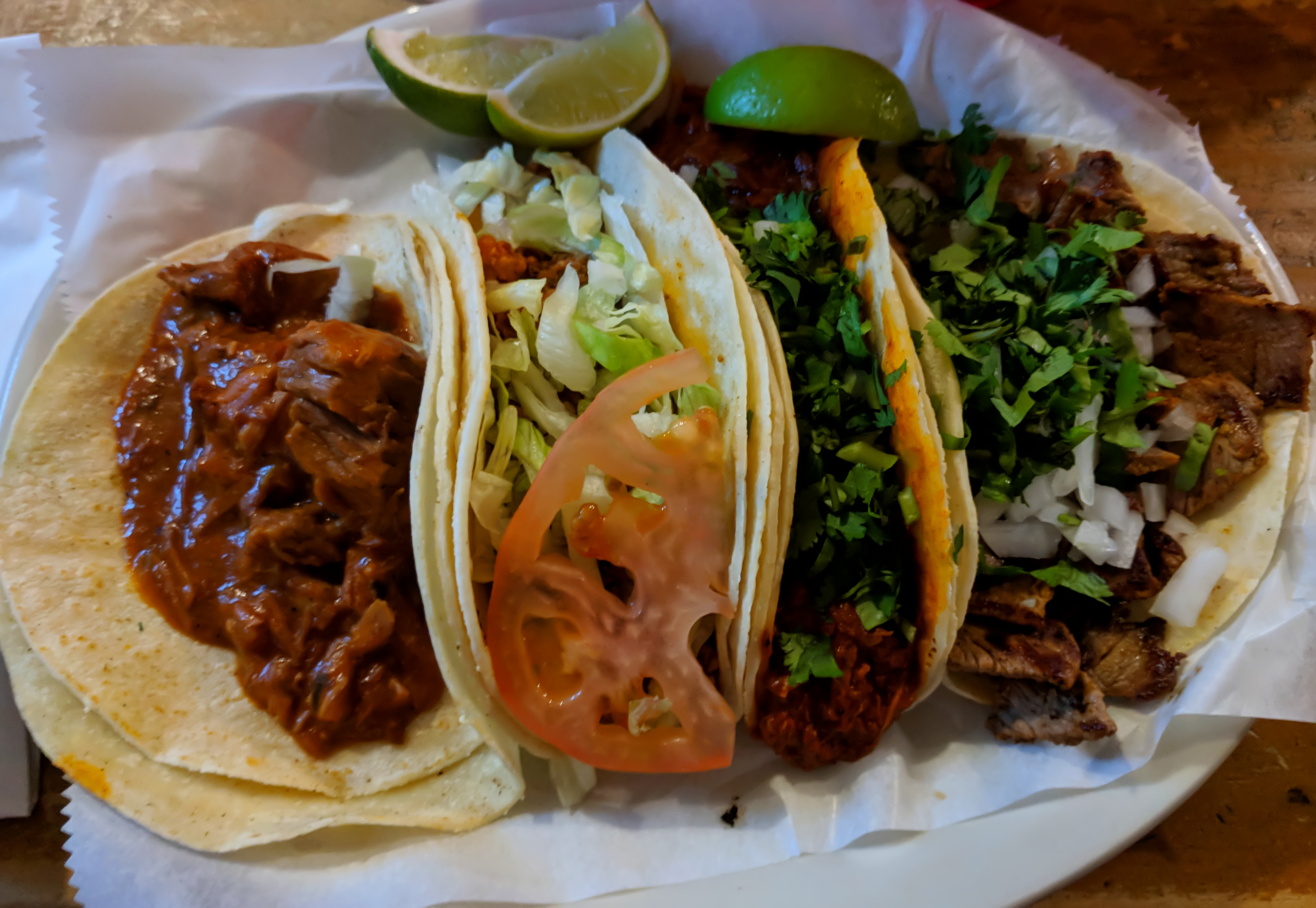 Four tasty tacos with a variety of vegetables and meats